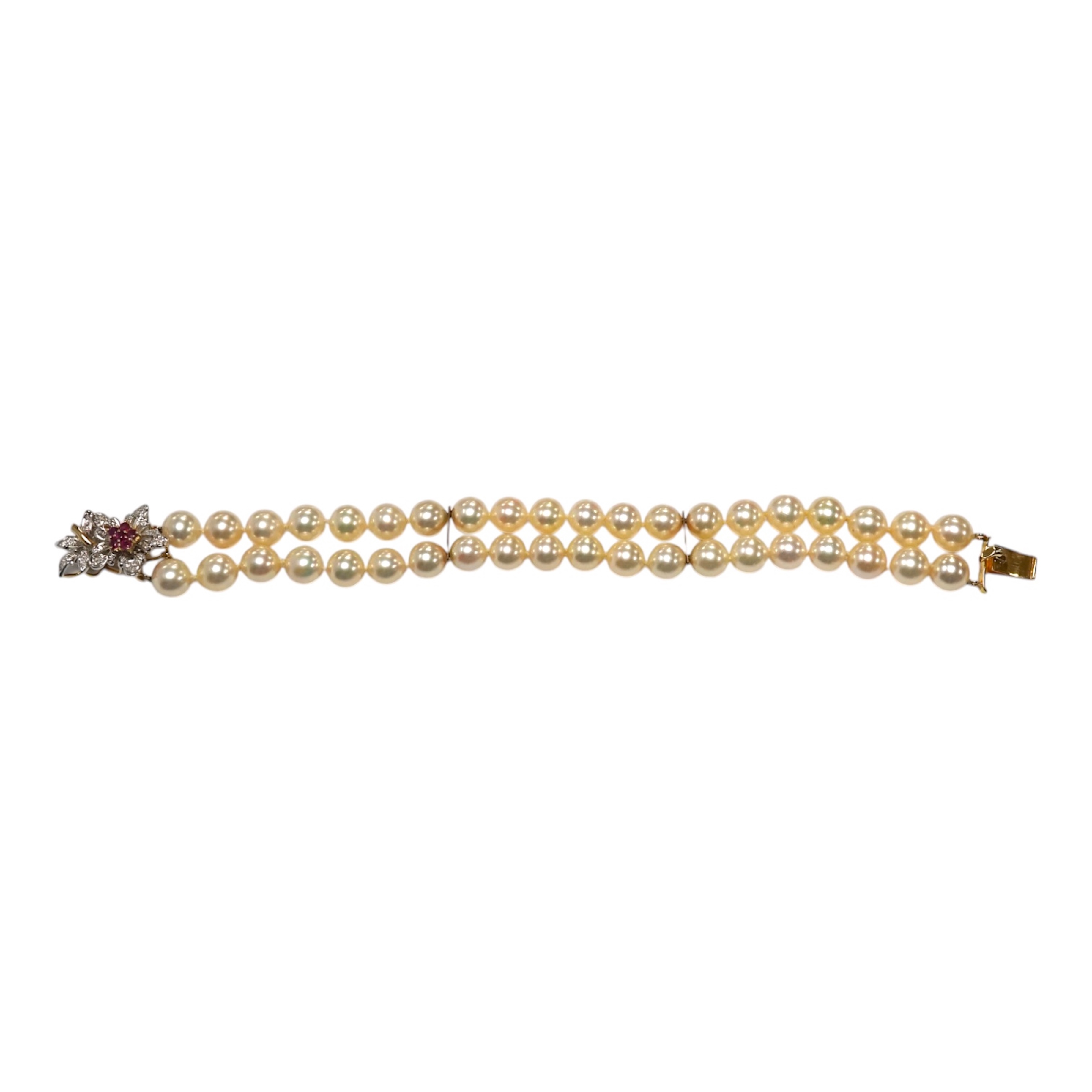 A double strand cultured pearl bracelet, with a ruby and diamond cluster set 14k clasp, 17.3cm. Condition - good